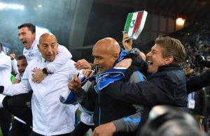 Một tifosi Napoli ôm HLV Spalletti (quàng khăn) và nâng cao tấm khiên bằng xốp ba màu in số 3, tượng trưng cho 3 lần vô địch Serie A